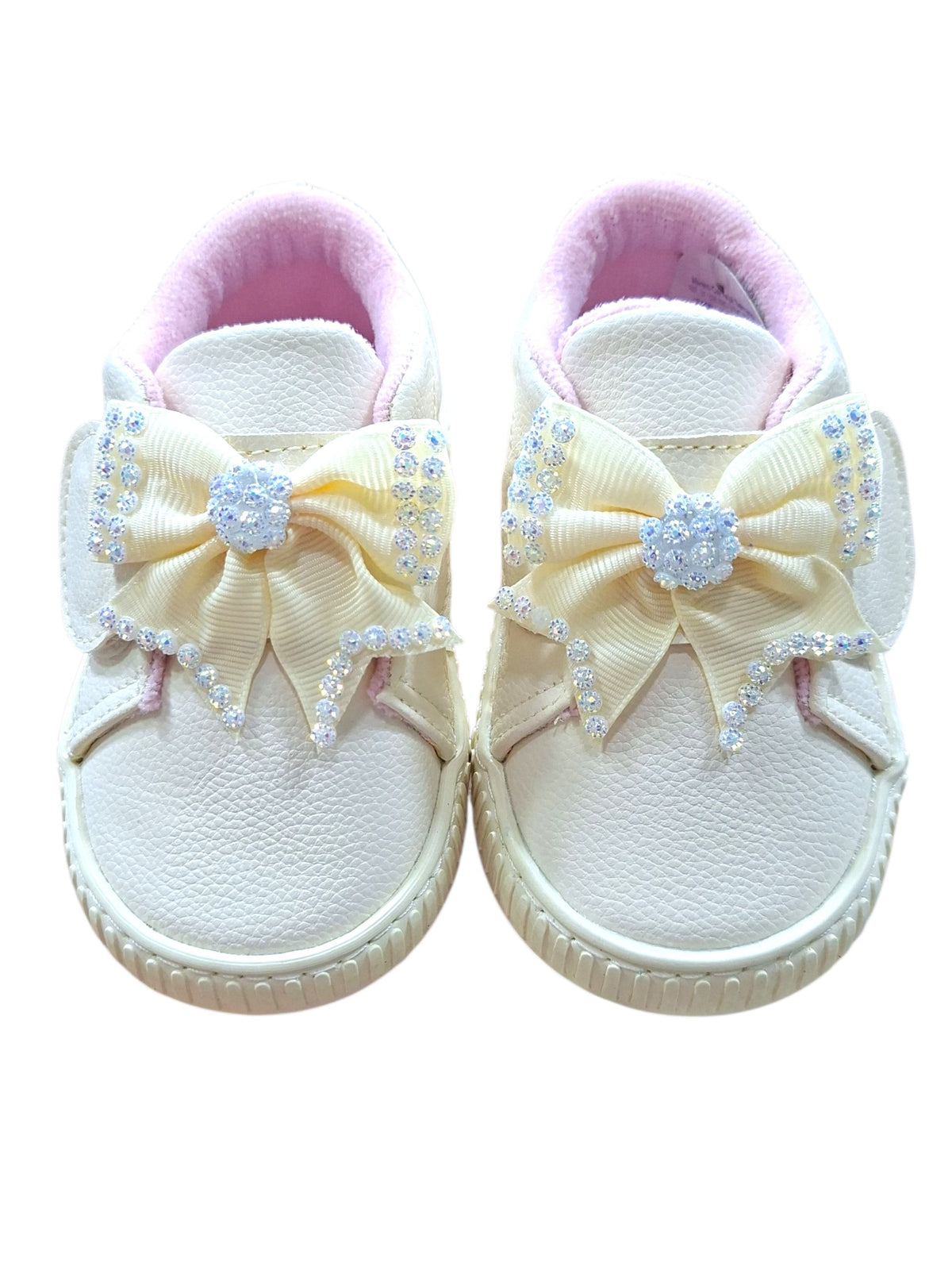 Tenis casuales Calzakids Moritas para niña en color blanco con moño decorativo brillante y detalles en rosa suave.