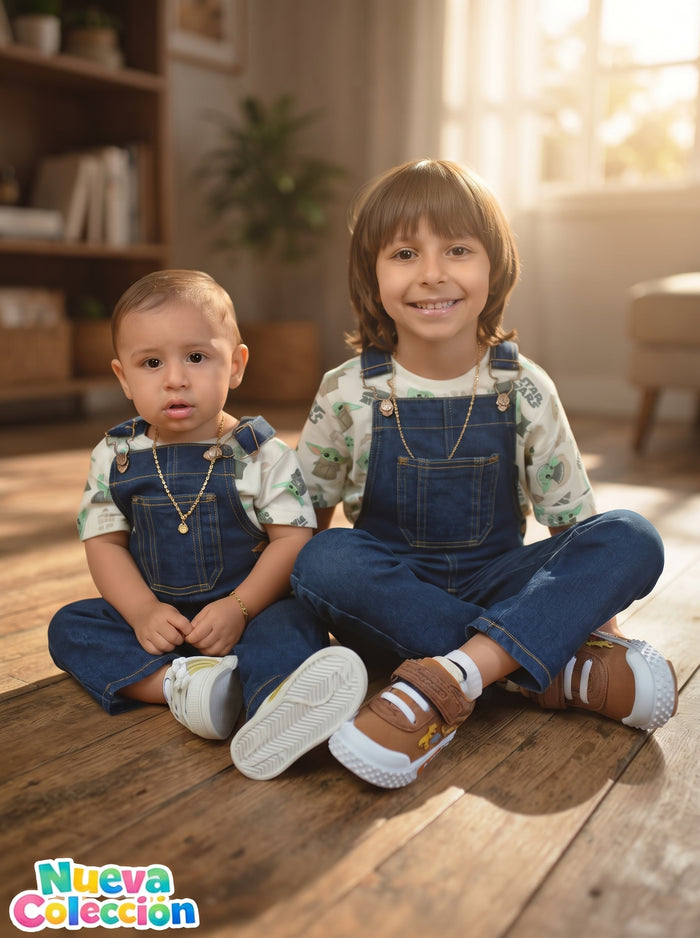 Dos hermanos en overol jugando en casa, con tenis puestos